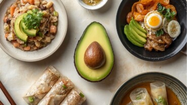 Cocina asiática con aguacate: sushi, bibimbap y rollitos vietnamitas alrededor de un aguacate fresco.